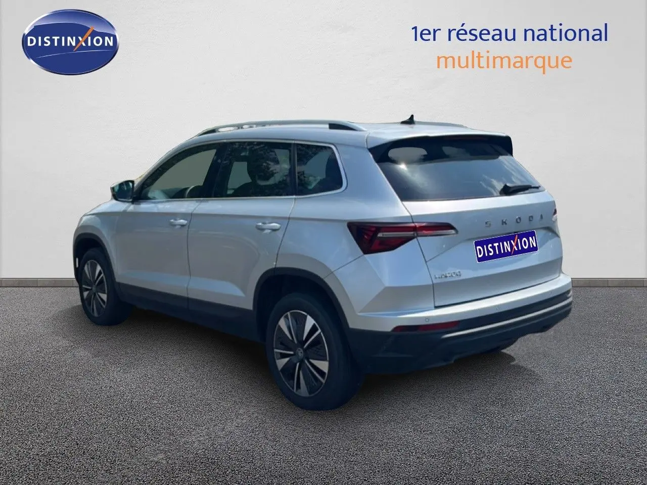 Vue 3/4 arrière droite d’un Skoda Karoq 2025 en Reflex Silver Metal avec feux arrière LED et jantes bi-ton.