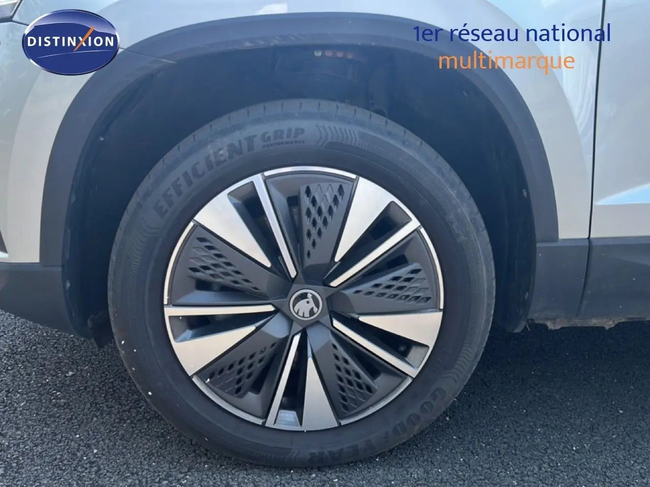 Gros plan sur la roue avant droite d’un Skoda Karoq Reflex Silver Metal, mettant en valeur la jante design bicolore.