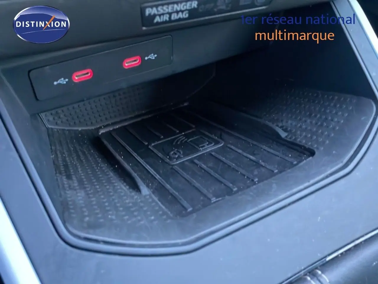 Gros plan sur la console centrale du SEAT Arona 2025, montrant la zone de recharge sans fil et deux ports USB rouges.
