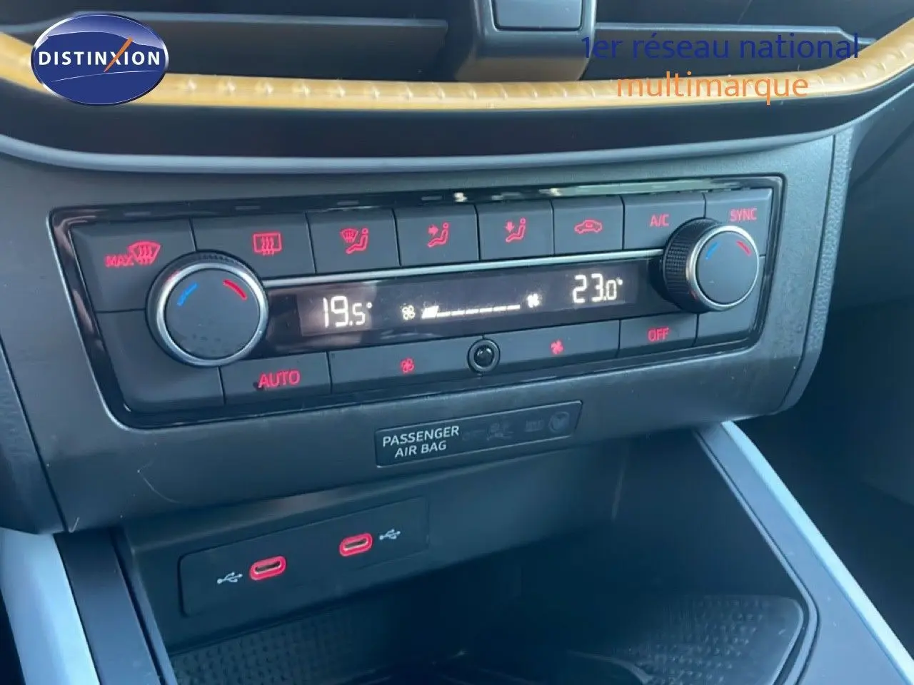 Gros plan sur la console centrale du SEAT Arona 2025, montrant la climatisation bi-zone et deux ports USB-C rouges.