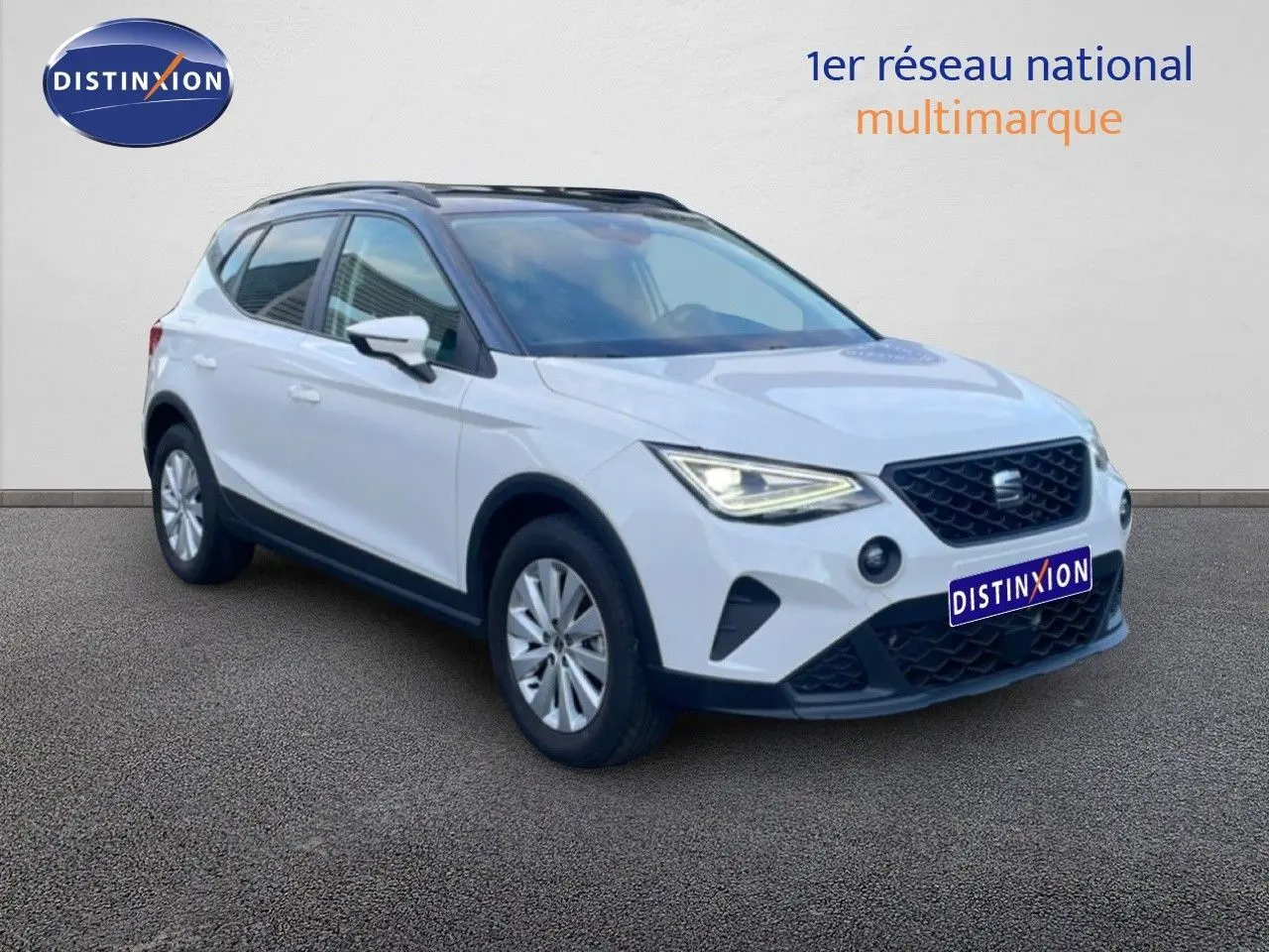 SEAT Arona blanc avec toit gris, vue 3/4 avant droit, phares allumés et calandre noire distinctive.