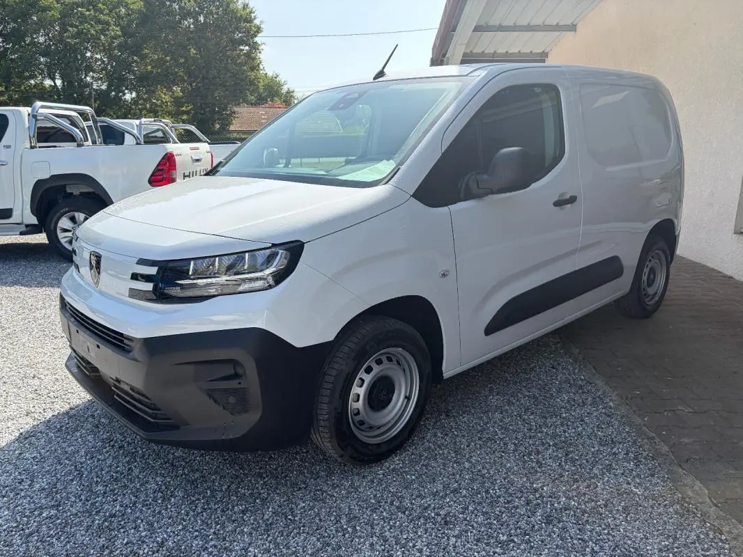 Vue 3/4 avant droite d’un Peugeot Partner blanc 2026, fourgon diesel avec pare-chocs noirs et jantes acier.