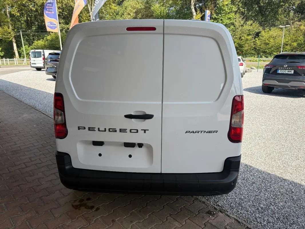 Vue arrière d’un Peugeot Partner blanc, fourgon utilitaire avec portes battantes et feux rouges verticaux.