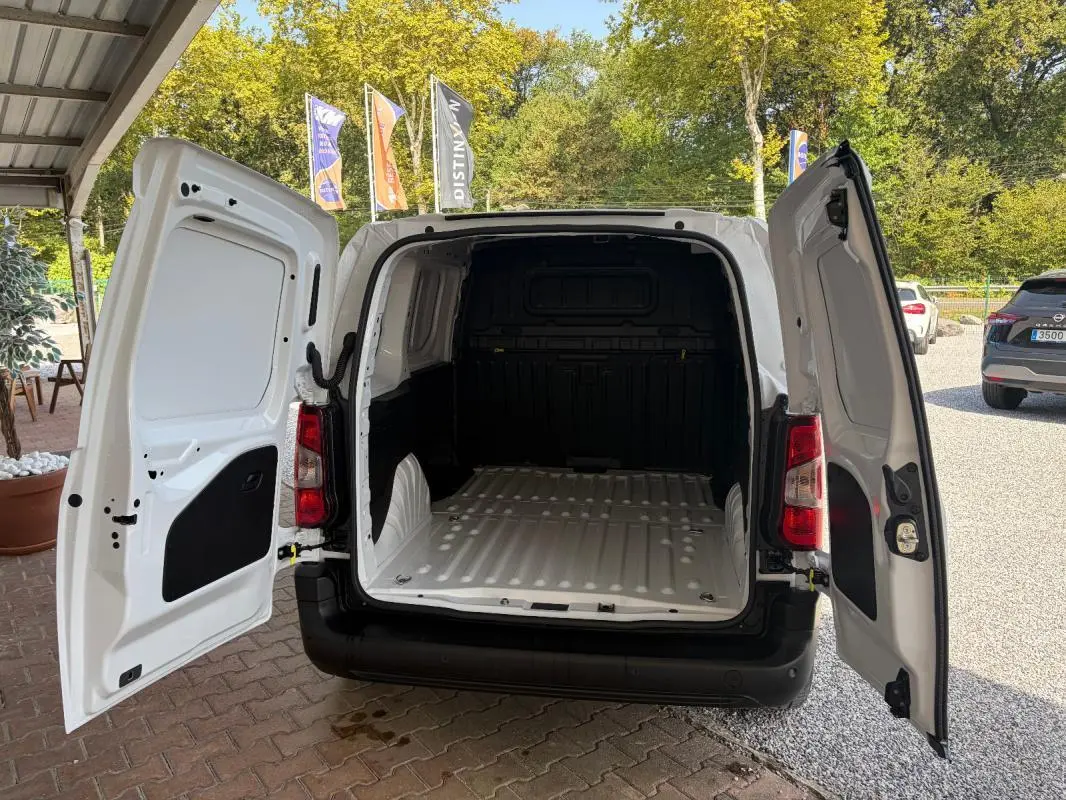 Vue arrière du Peugeot Partner blanc 2026 avec portes arrière ouvertes montrant l’espace de chargement vide.