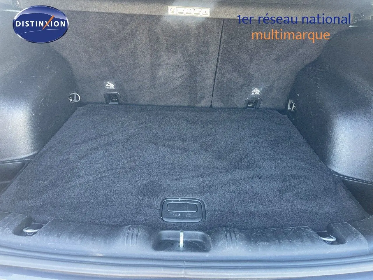 Coffre ouvert du Jeep Compass gris foncé, vue de l'arrière montrant l'espace de chargement propre et tapis noir.
