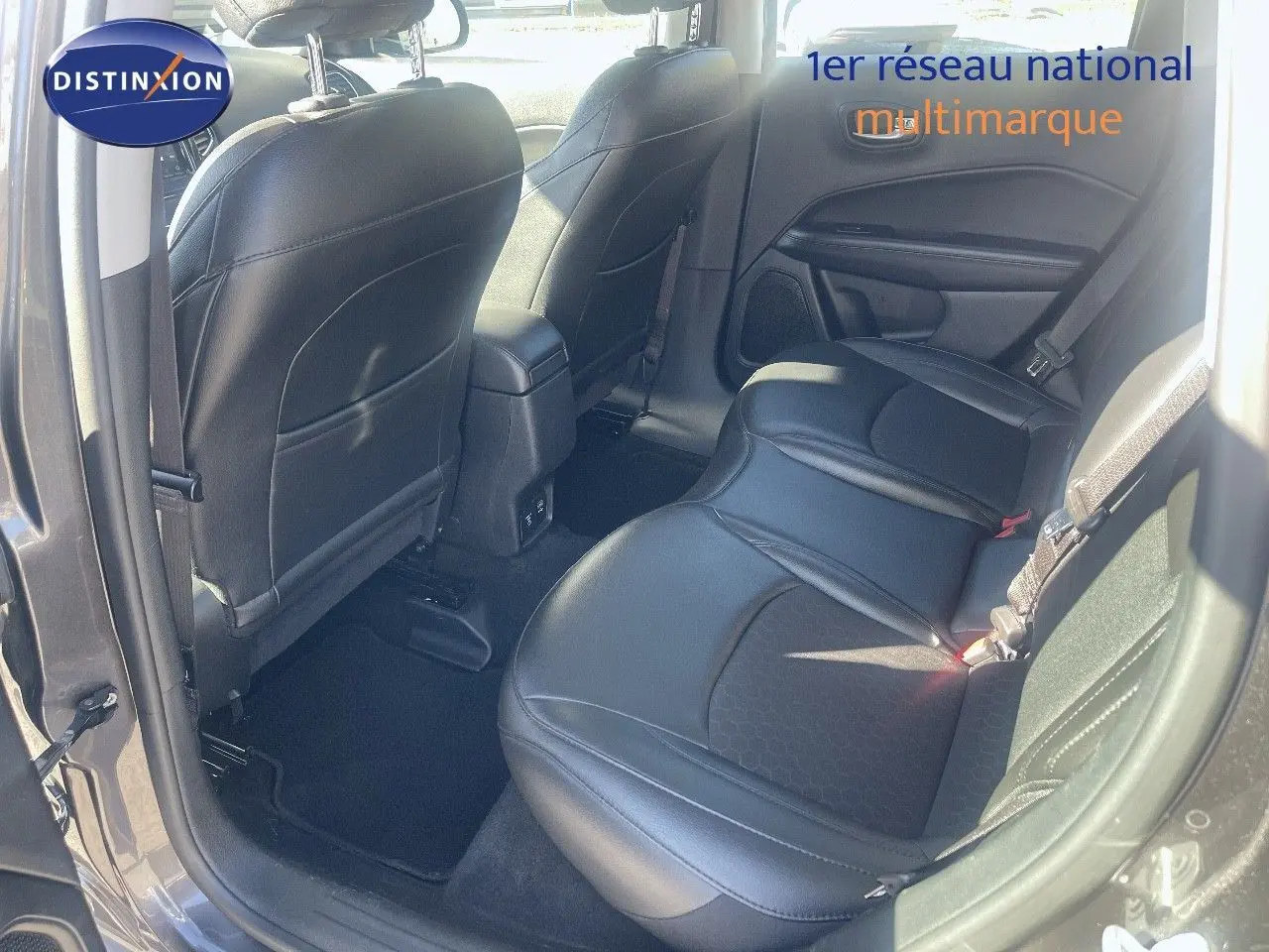 Vue intérieure arrière côté droit du Jeep Compass gris foncé, montrant les sièges en cuir noir et la porte ouverte.