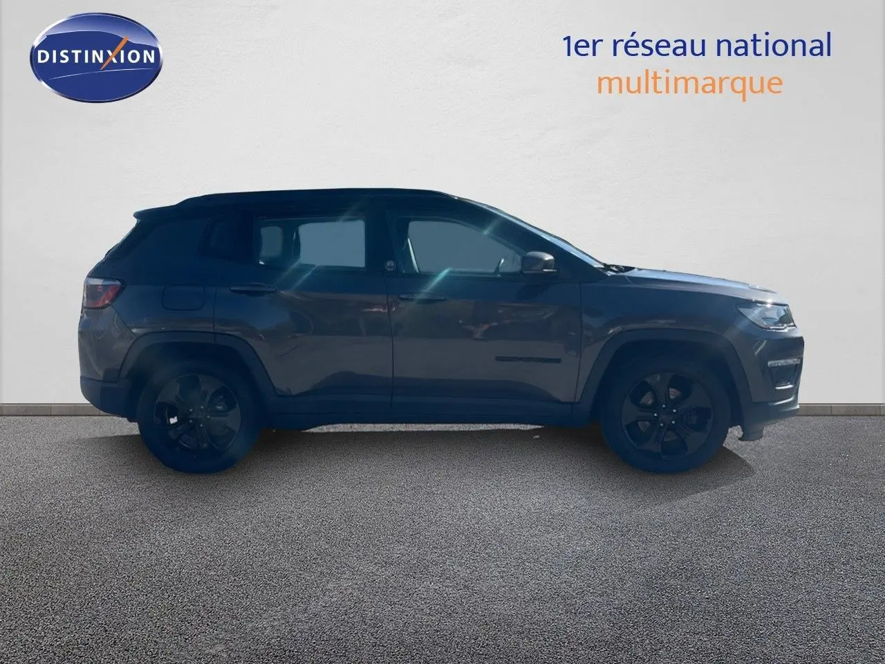 Vue de profil côté gauche d'un Jeep Compass gris foncé Brooklyn Edition 2019 avec jantes noires.
