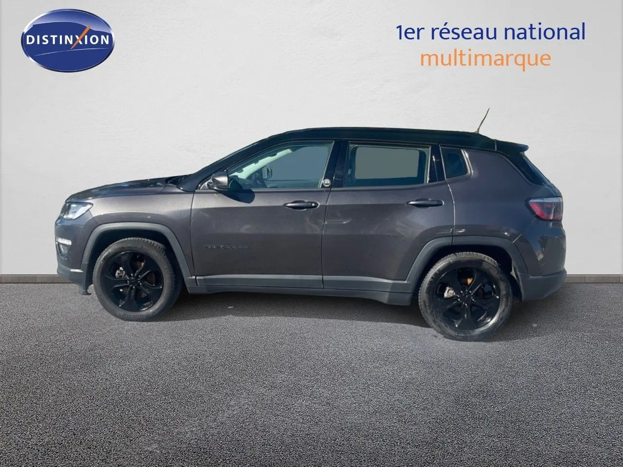 Vue de profil côté gauche d'un Jeep Compass gris foncé Brooklyn Edition 2019 avec jantes noires et toit noir.