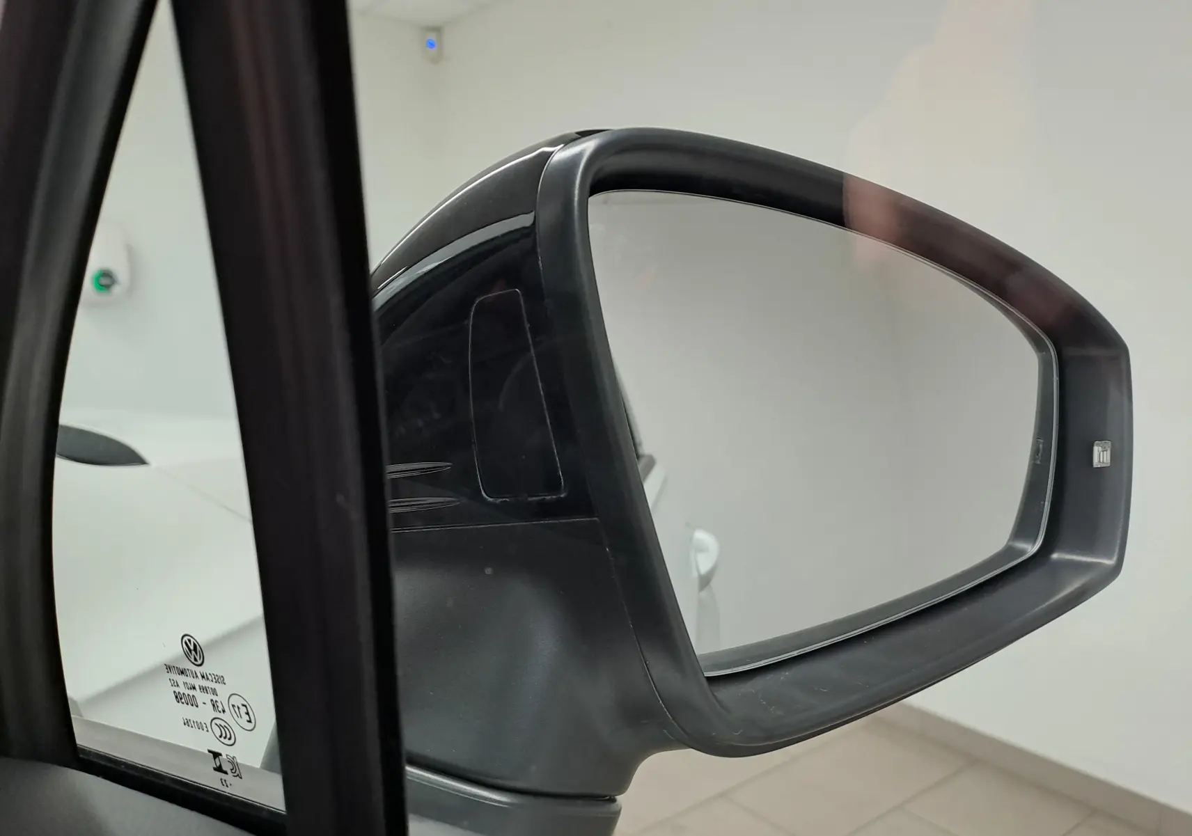 Rétroviseur extérieur droit noir du Volkswagen Tiguan blanc nacré 2023, vue rapprochée depuis l'intérieur.