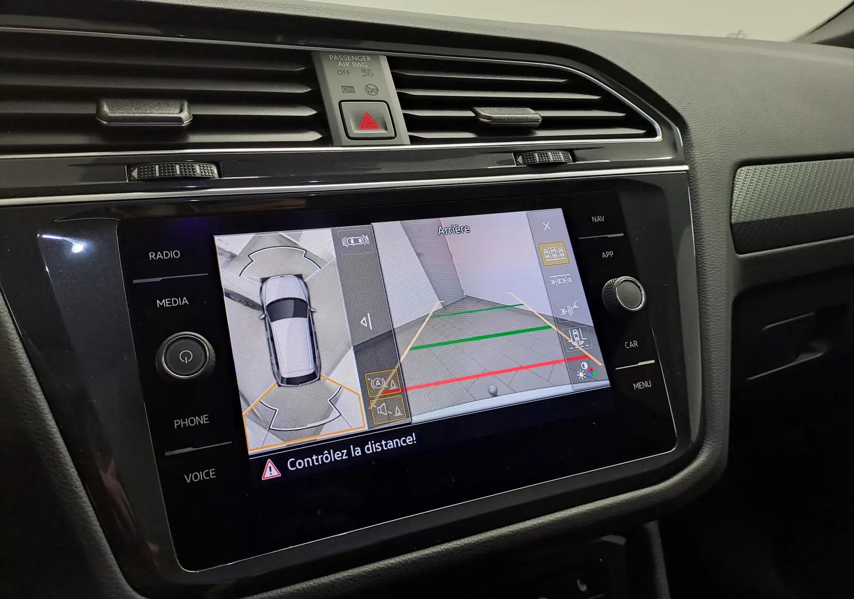 Écran central du Volkswagen Tiguan 2023 montrant la caméra de recul et la vue 360° intérieure, tableau de bord noir.