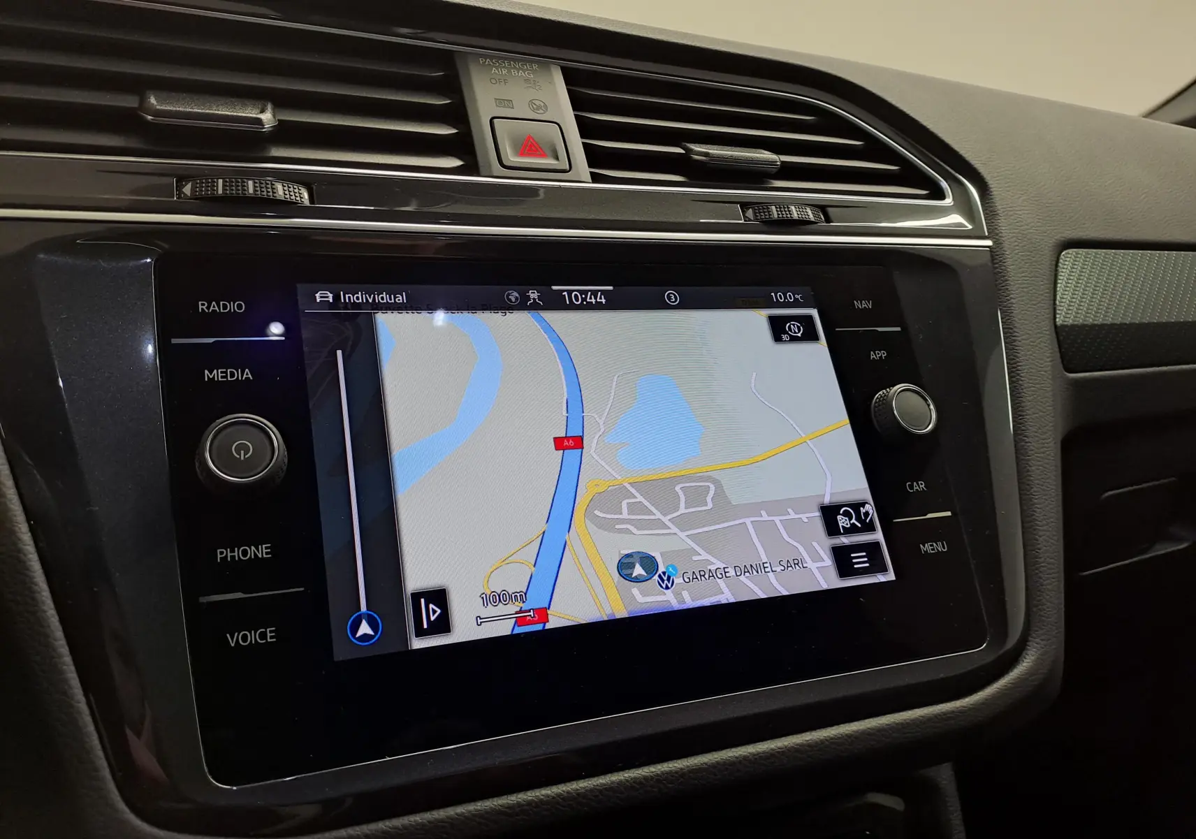 Écran tactile central du tableau de bord du Volkswagen Tiguan 2023 montrant la navigation GPS en intérieur noir.