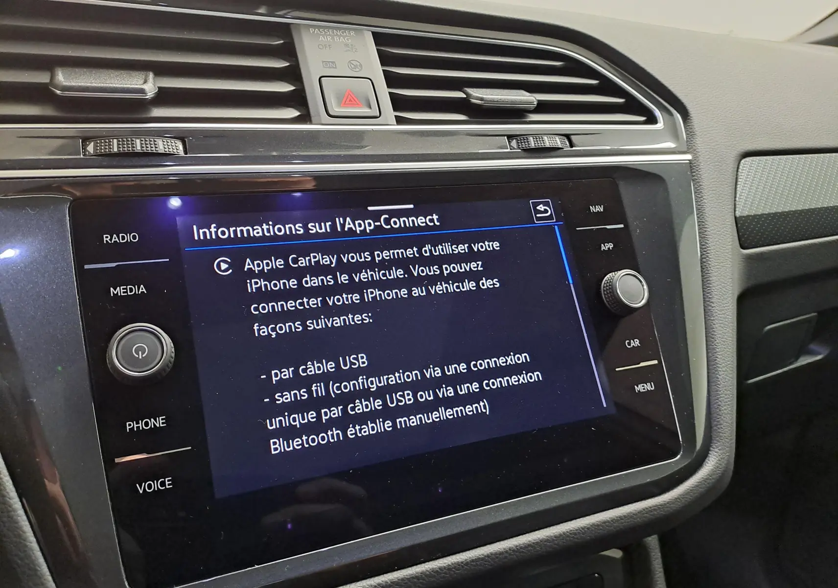 Vue intérieure du tableau de bord du Volkswagen Tiguan 2023, écran tactile affichant les options Apple CarPlay.