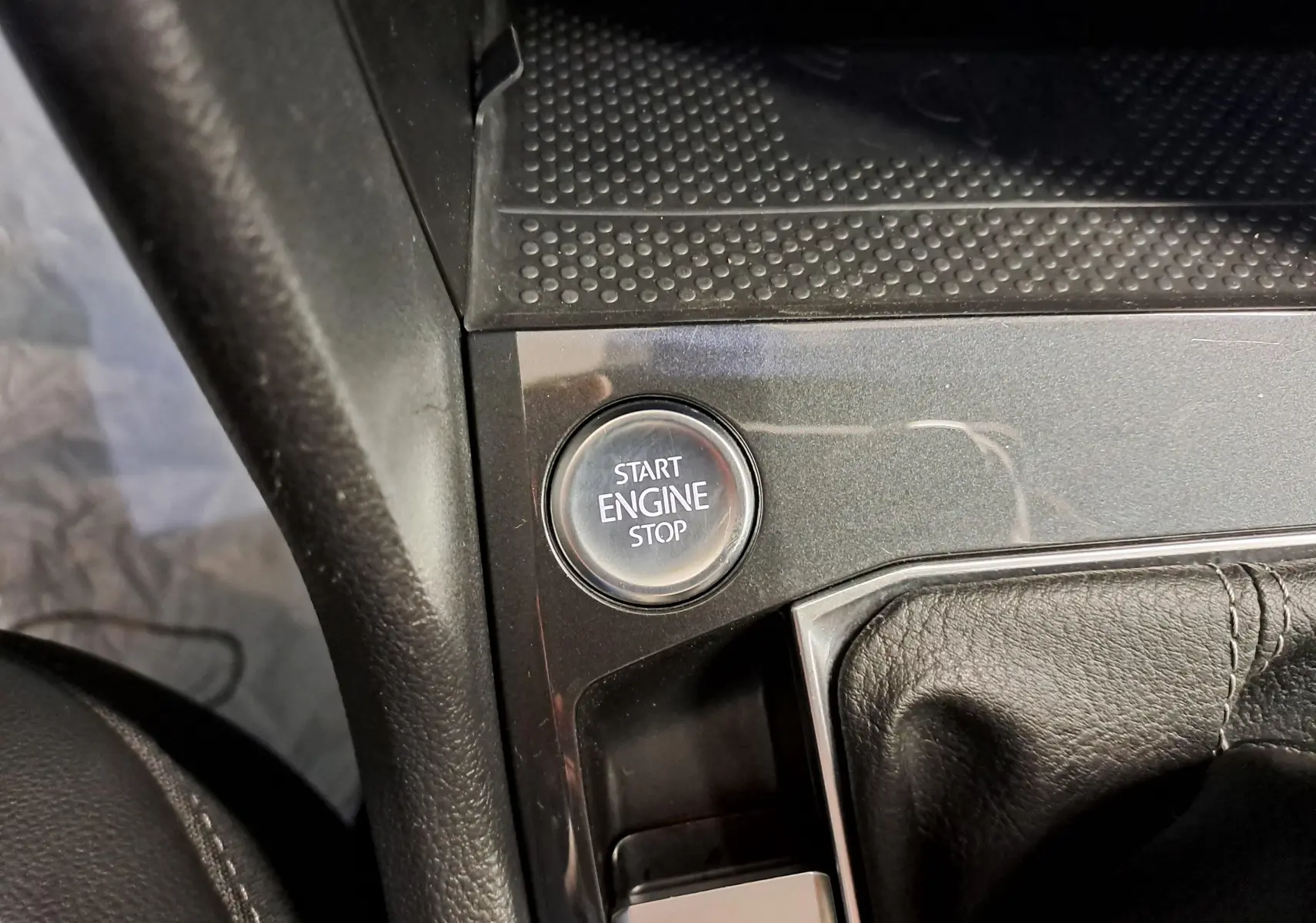 Gros plan sur le bouton Start Engine Stop dans l’habitacle du Volkswagen Tiguan 1.4 eHybrid 2023, entouré de cuir noir.