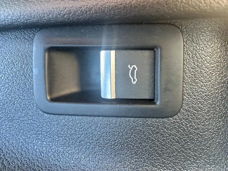 Gros plan sur le bouton d'ouverture du coffre noir dans l'habitacle de l'Audi A5 Sportback 2018.