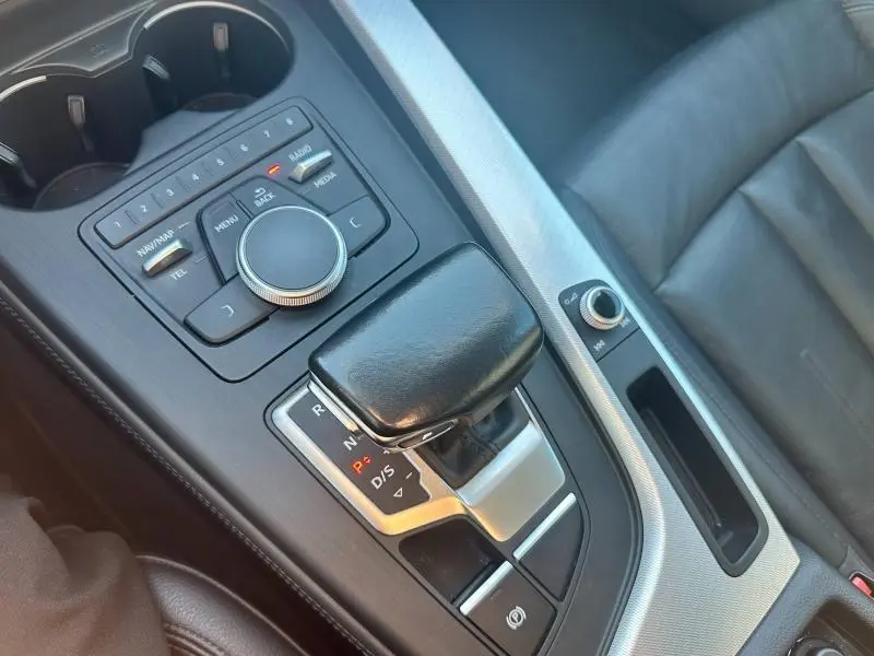 Vue rapprochée de la console centrale noire et argentée avec levier de vitesse automatique et commandes multimédia d'une Audi A5 Sportback 2018.