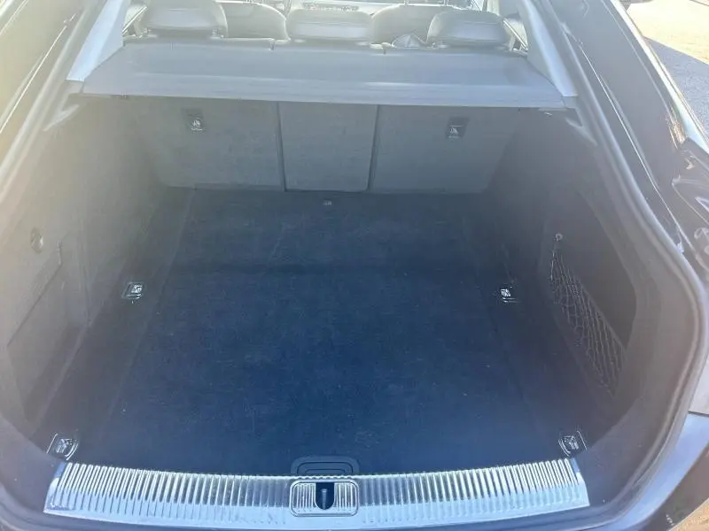 Vue plongeante sur le coffre noir spacieux et propre de l'Audi A5 Sportback 2018, avec filet de rangement latéral.
