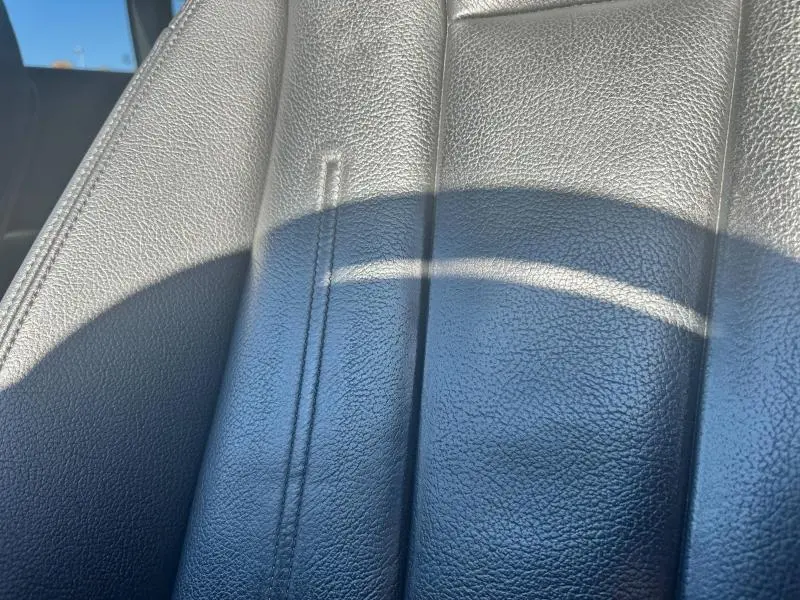 Gros plan sur le cuir noir texturé d’un siège avant de l’Audi A5 Sportback 2018, éclairé par la lumière naturelle.