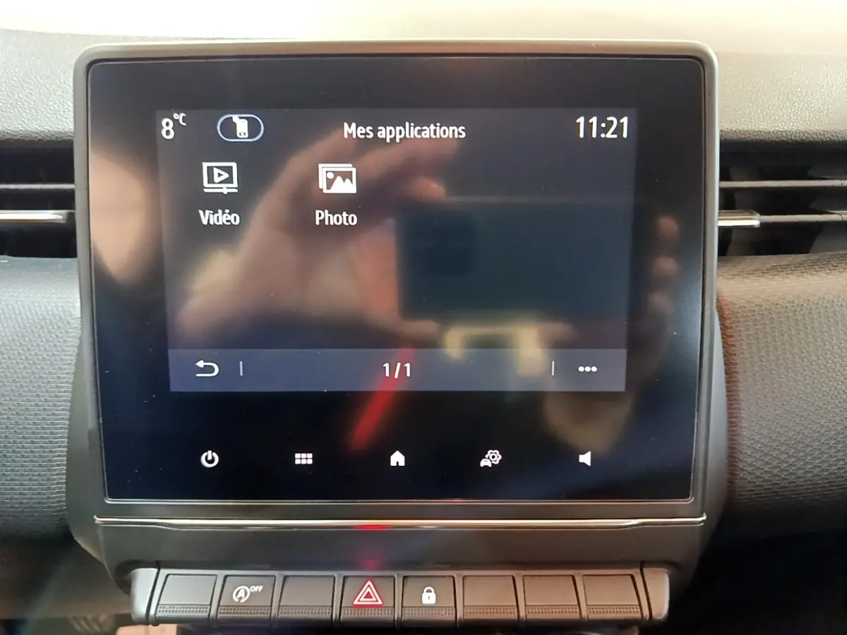 Écran tactile central affichant les applications vidéo et photo dans l’habitacle d’une Renault Clio Business blanche.