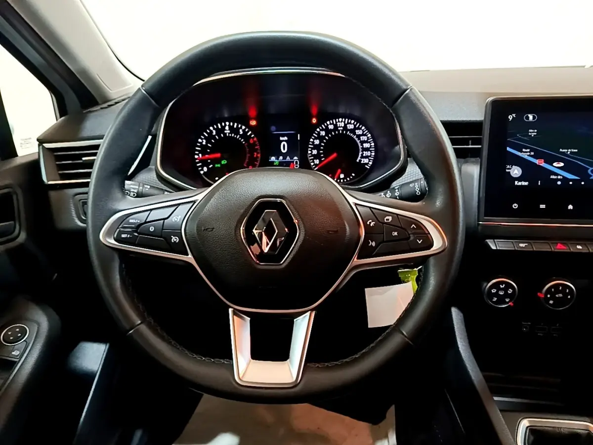 Vue intérieure centrée sur le volant cuir noir de la Renault Clio Business 2021 avec tableau de bord et écran tactile.