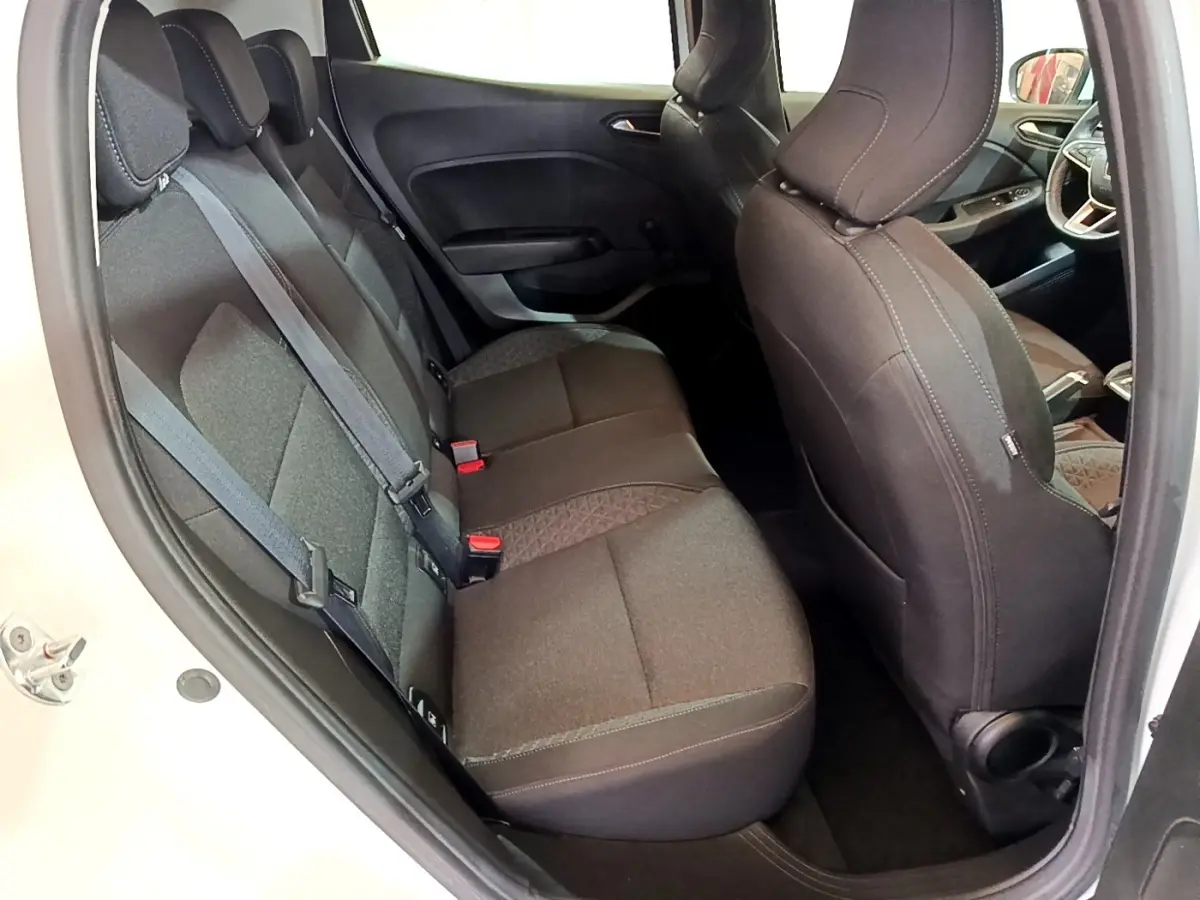 Vue intérieure côté arrière droit de la Renault Clio Business blanche, montrant les sièges arrière en tissu gris foncé.