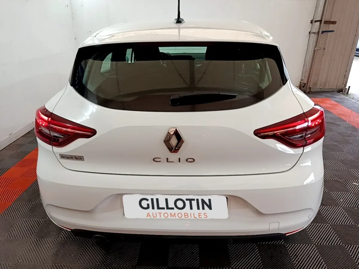 Vue arrière d'une Renault Clio Business blanche, avec feux LED distinctifs et logo Renault centré.