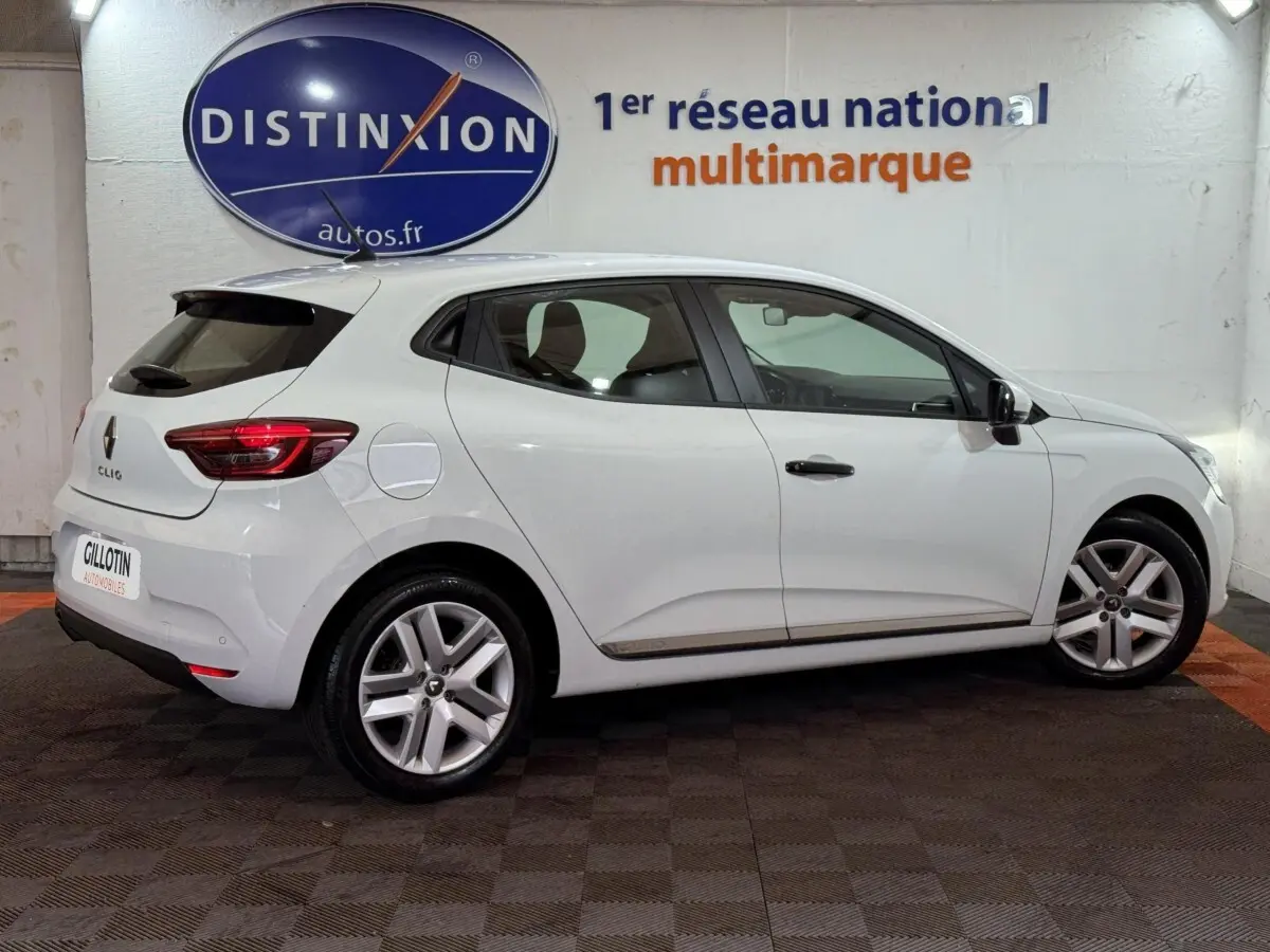 Renault Clio Business blanche vue de profil côté droit, avec jantes alliage et toit spoiler noir.