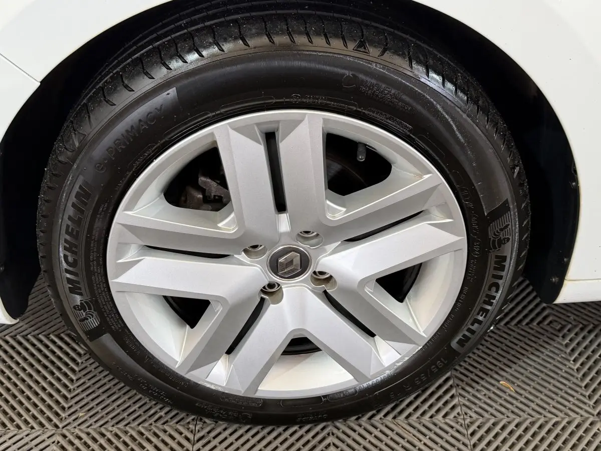 Vue rapprochée de la roue arrière droite d'une Renault Clio Business blanche, pneu Michelin visible.
