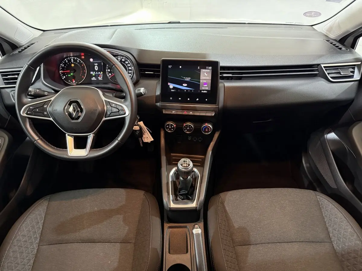 Vue intérieure avant de la Renault Clio Business 2020 avec tableau de bord noir, volant multifonctions cuir et écran tactile central.