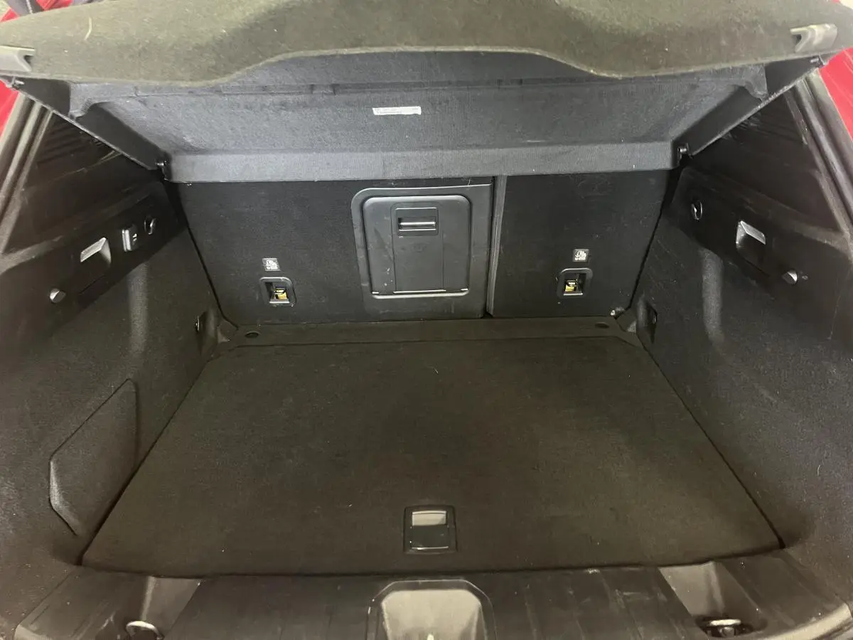 Coffre ouvert de l'Alfa Romeo Tonale rouge 2024, vue intérieure arrière montrant l'espace de chargement noir.