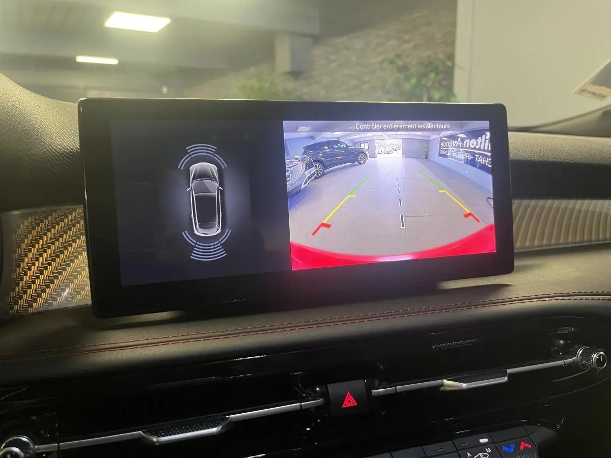 Écran central de l'Alfa Romeo Tonale 2024 affichant la caméra de recul et l'aide au stationnement en intérieur.