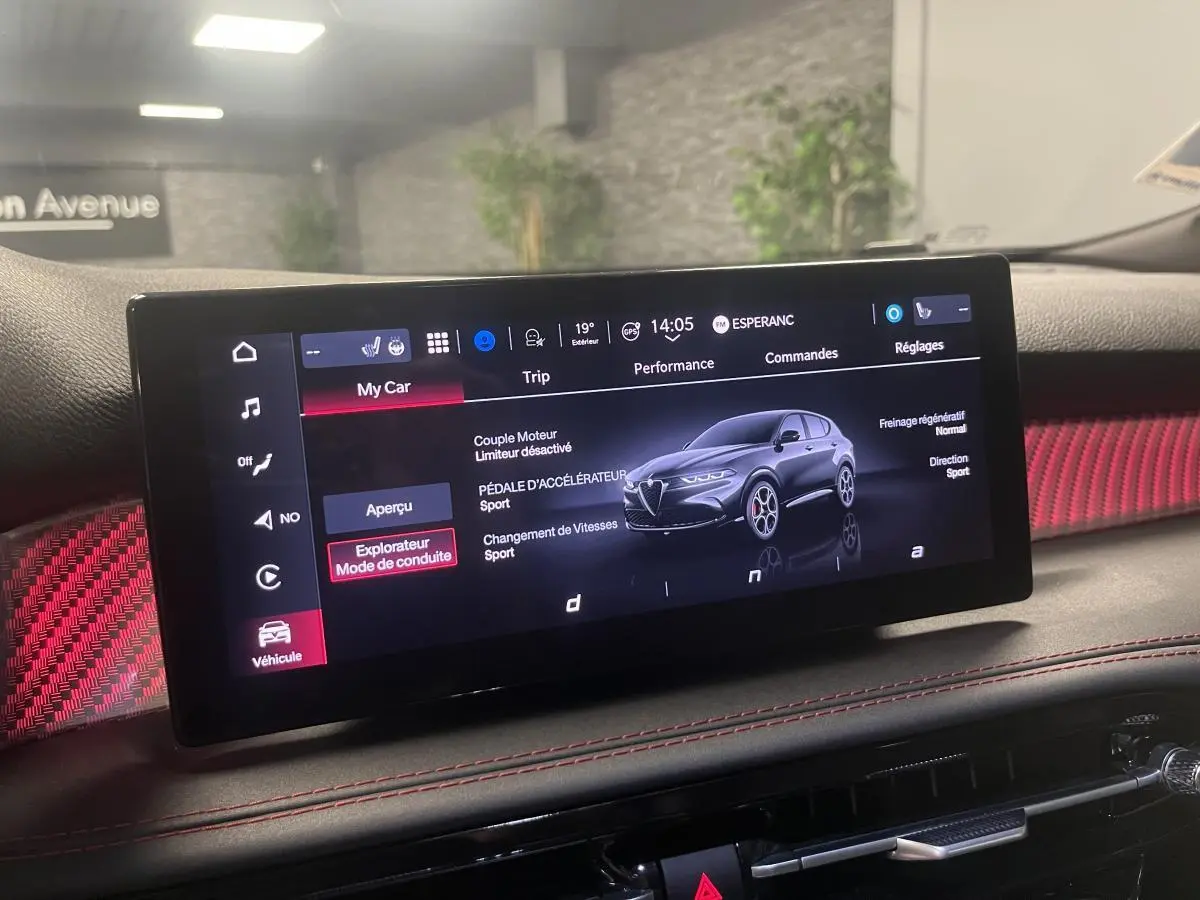 Écran tactile intérieur de l'Alfa Romeo Tonale 2024 affichant les modes de conduite avec habillage rouge et surpiqûres.