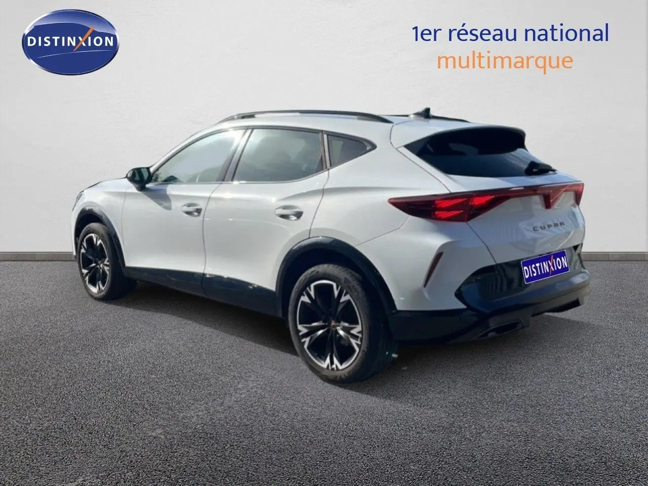 Vue 3/4 arrière droite du CUPRA Formentor blanc neige métal avec jantes noires et détails sportifs visibles.