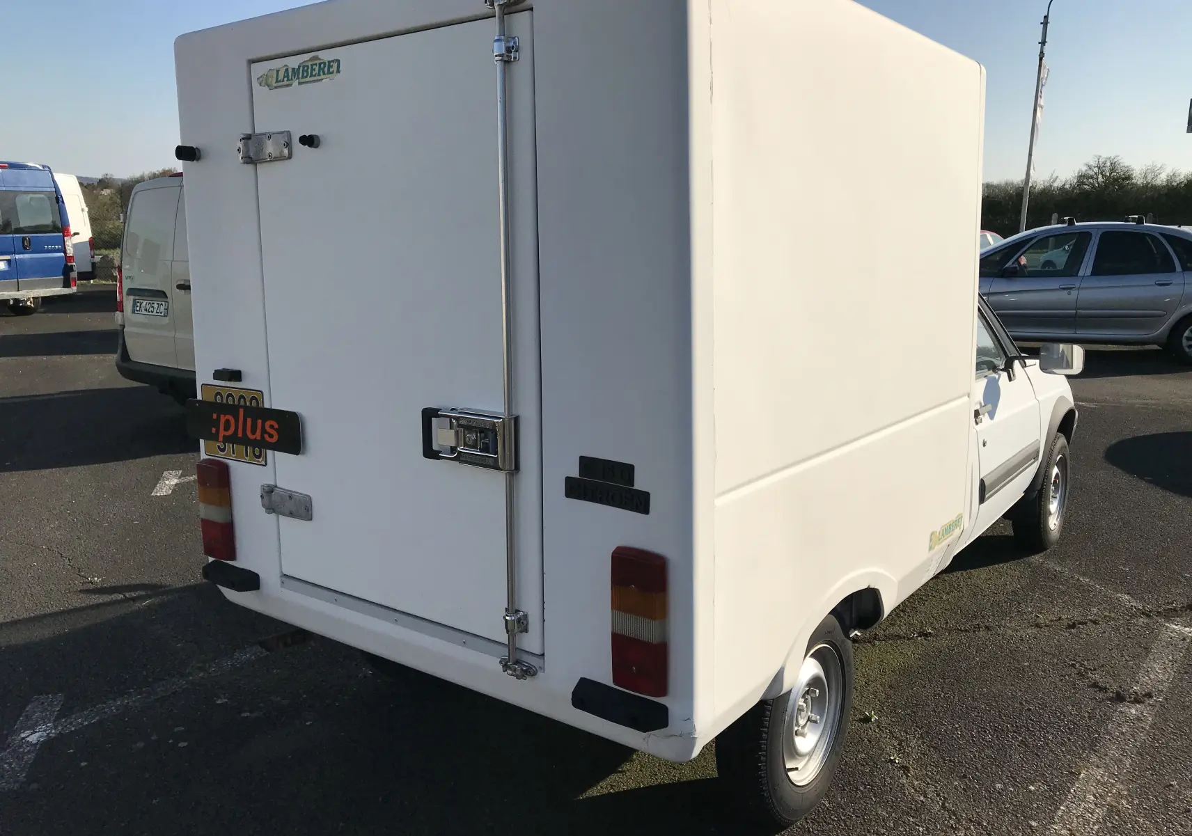 Vue 3/4 arrière droite d'un utilitaire blanc Citroën C15 Isotherm de 1997 avec caisse frigorifique et porte arrière verrouillée.