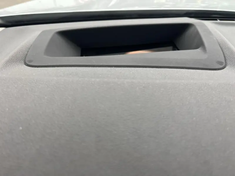 Gros plan sur l'écran encastré dans le tableau de bord gris foncé de la BMW X3 xDrive30eA 2020.