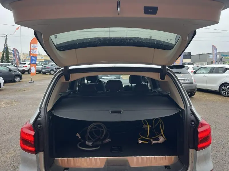 Vue arrière ouverte d'un BMW X3 xDrive30eA GlacierSilver 2020 montrant le coffre avec câbles de recharge hybride.