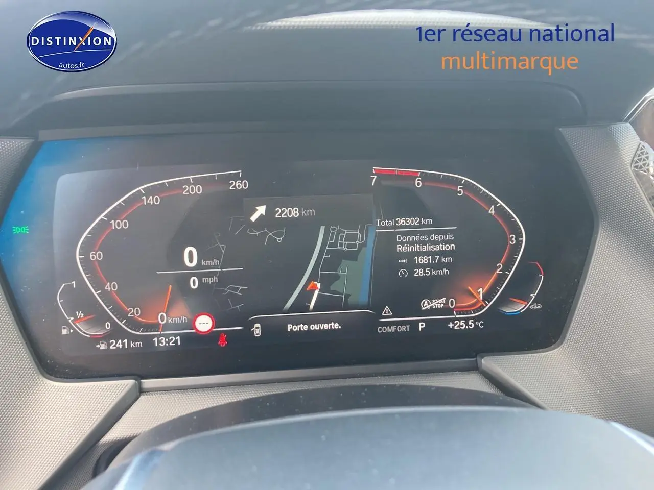 Vue rapprochée du tableau de bord numérique de la BMW Série 1 gris foncé, affichant la vitesse et la navigation.