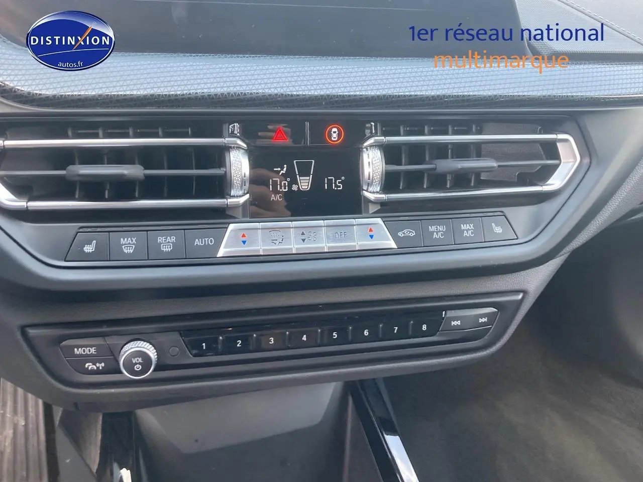 Vue rapprochée du tableau de bord de la BMW Série 1 gris foncé, montrant les commandes de climatisation et audio.