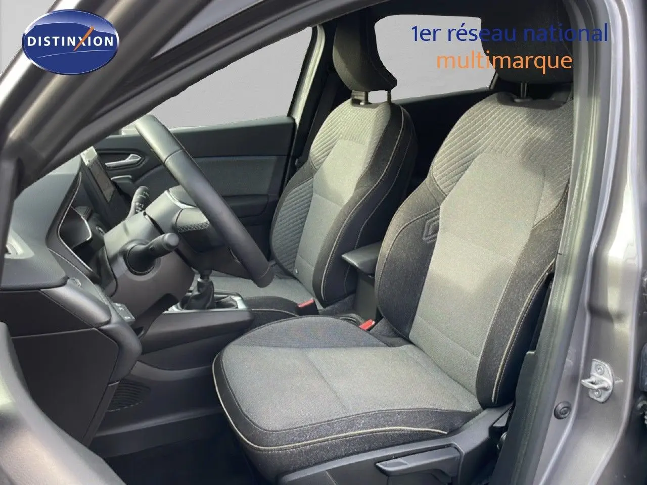 Vue intérieure côté conducteur du Renault Captur 1.0 ECO-G 100CH TECHNO 2025, sièges tissu gris et volant multifonction.