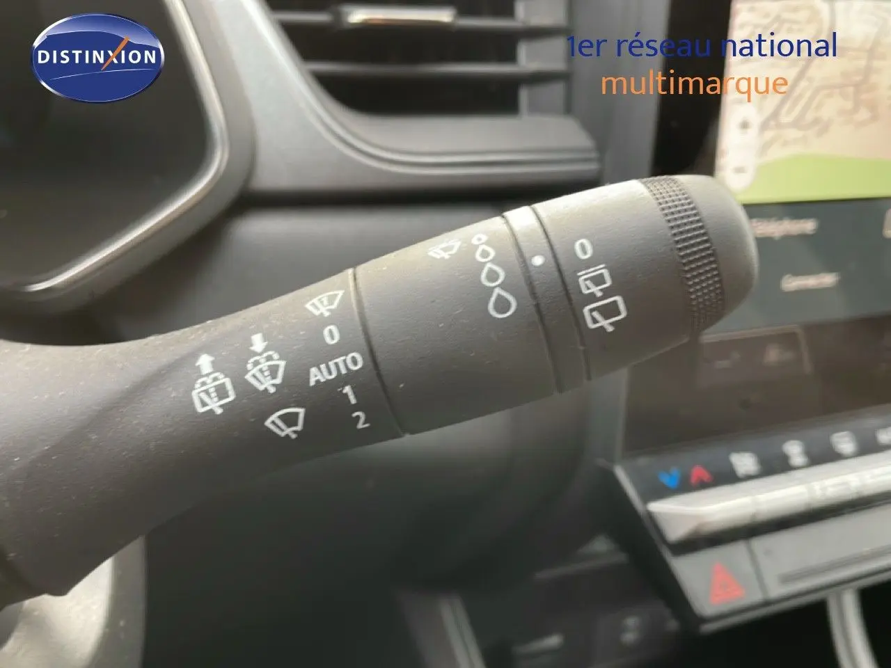 Gros plan sur la commande d'essuie-glace du Renault Captur 2025, intérieur noir avec tableau de bord visible en arrière-plan.