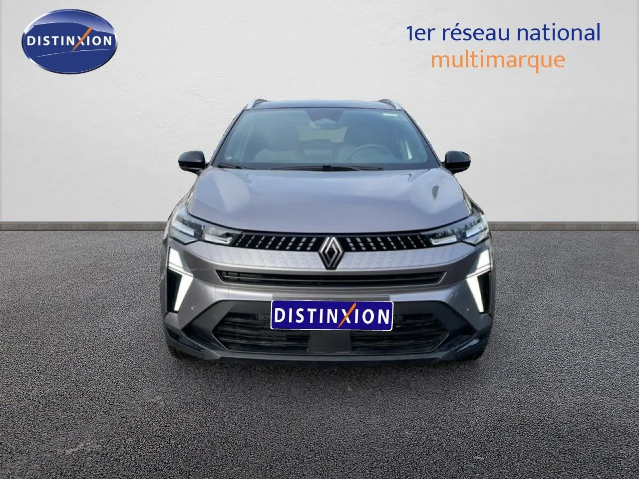 Vue de face du Renault Captur gris cassiopée métal avec toit noir, mettant en valeur ses feux LED distinctifs allumés.