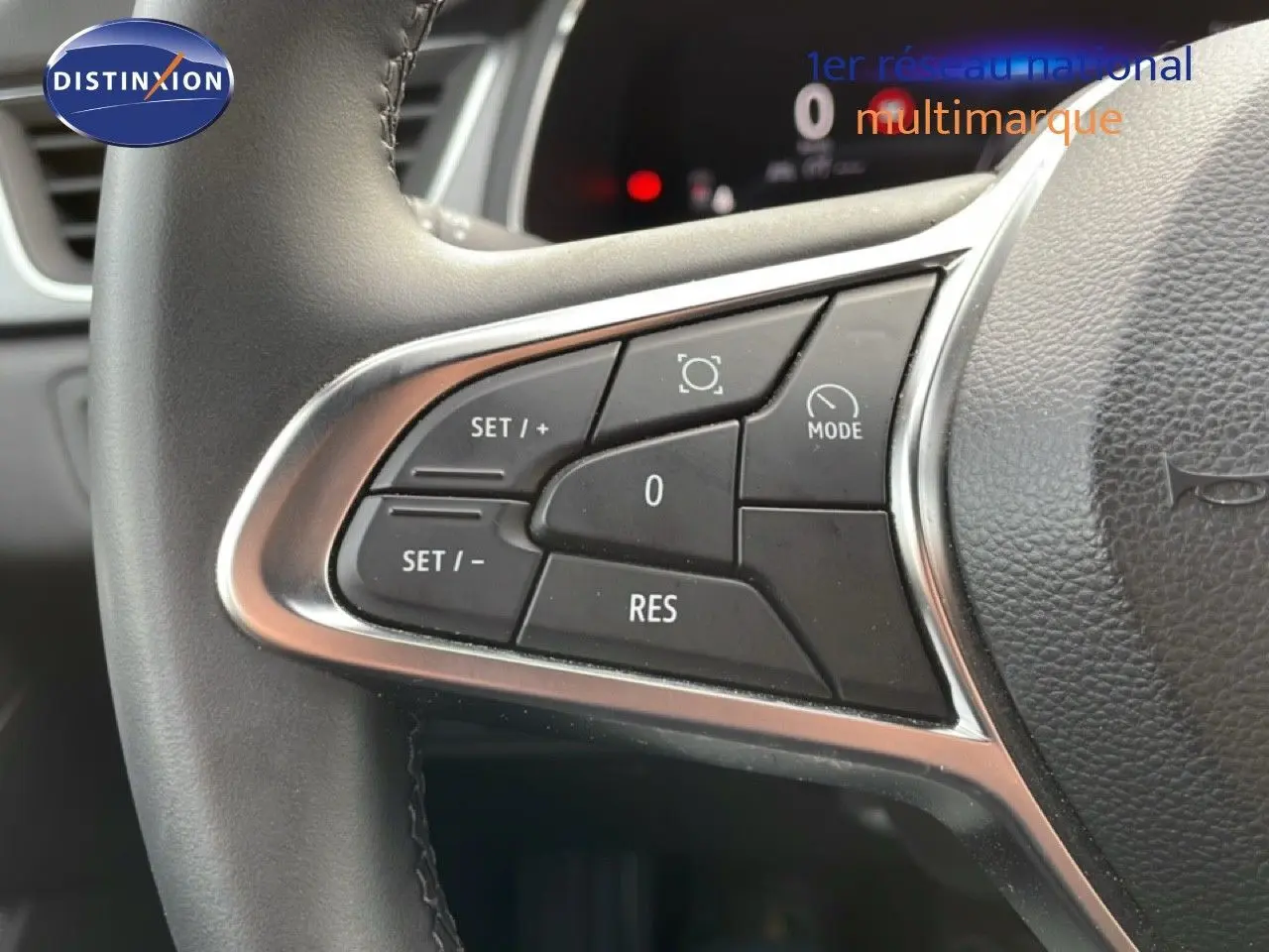 Gros plan sur les commandes au volant du Renault Captur 2025, finition gris Cassiopée métal avec toit noir.