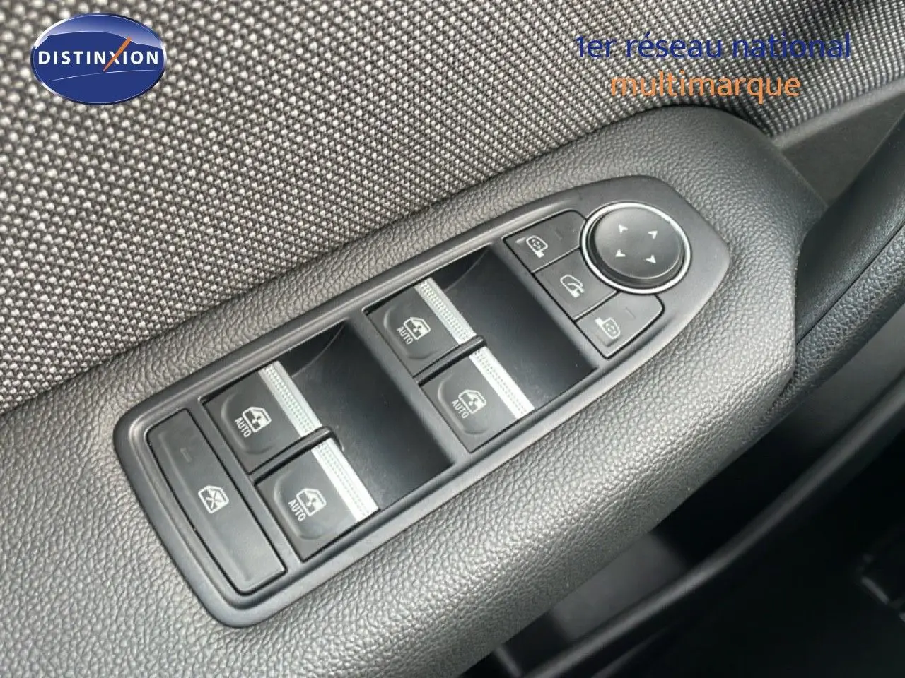 Gros plan sur les commandes de lève-vitres et rétroviseurs côté conducteur du Renault Captur gris cassiopée métal avec toit noir.