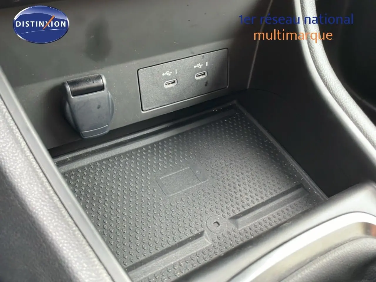 Gros plan sur la console centrale du Renault Captur gris Cassiopée, montrant les ports USB et un espace de rangement.