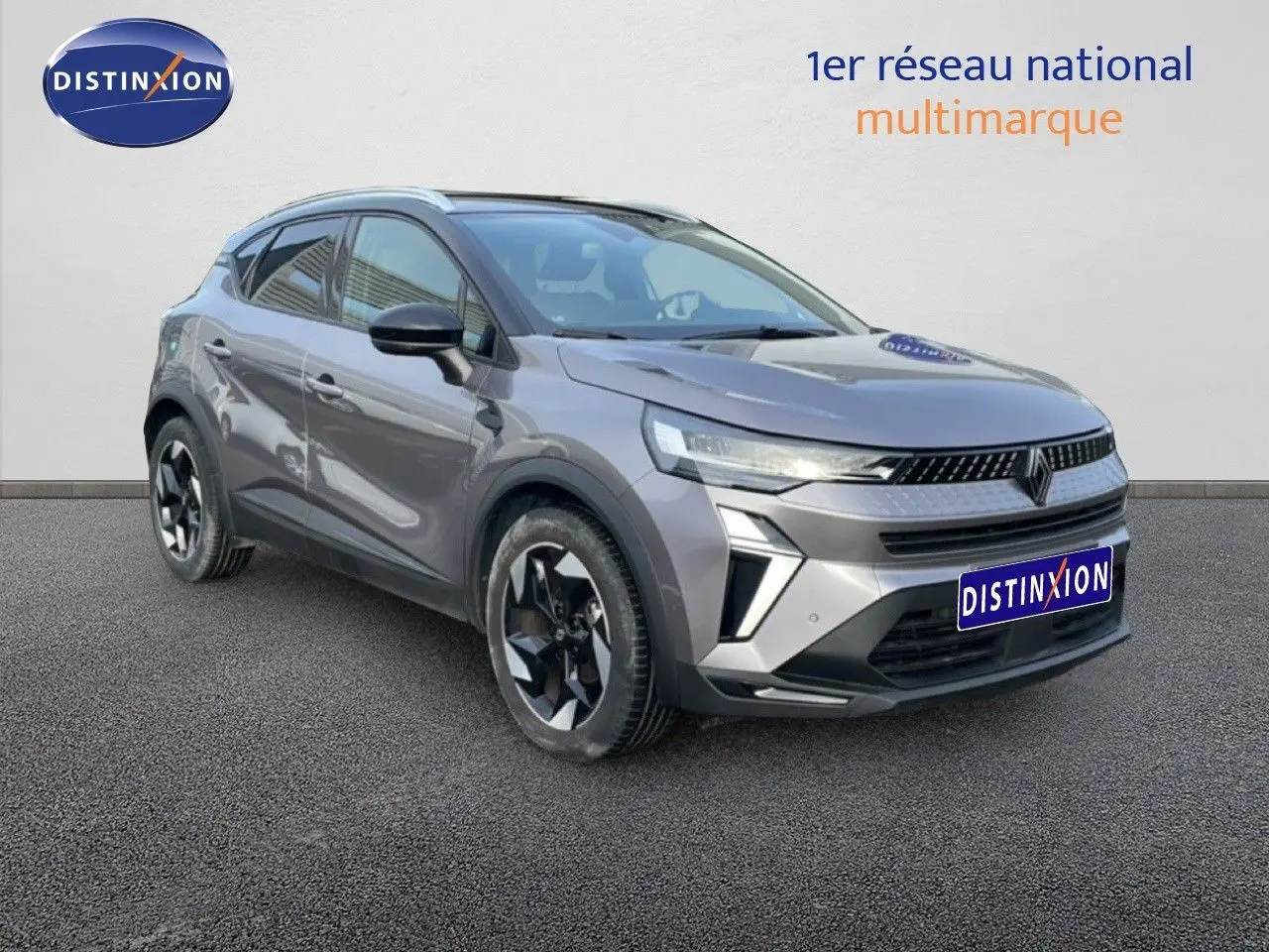 Renault Captur gris cassiopée métal avec toit noir, vue 3/4 avant mettant en valeur ses phares LED et jantes bicolores.