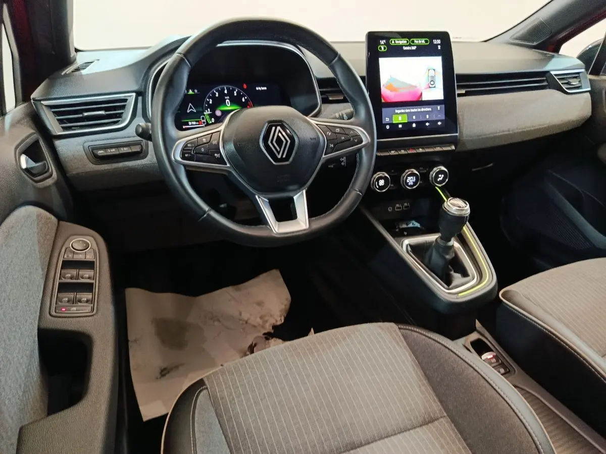 Vue intérieure avant de la Renault Clio Techno TCe 90 2024, montrant le volant, la boîte manuelle et l’écran tactile central.
