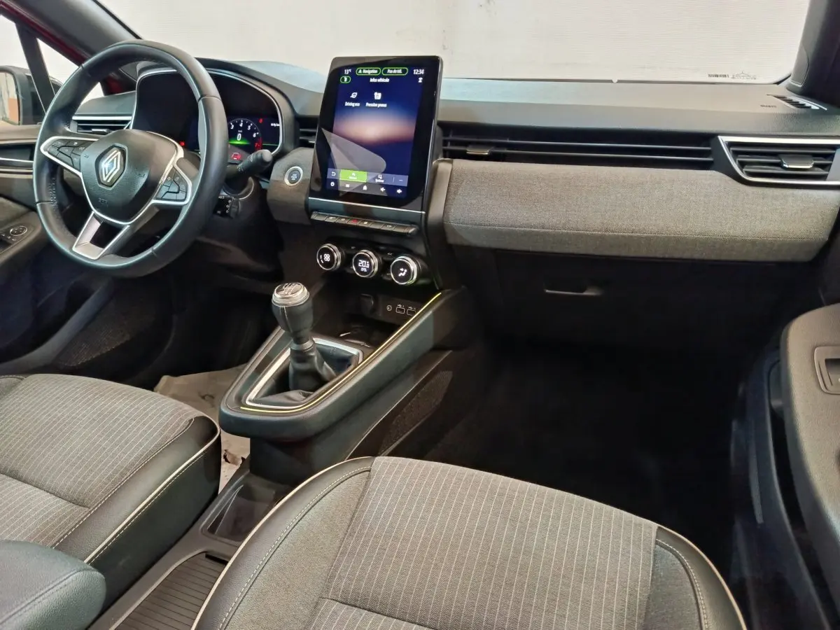 Vue intérieure avant de la Renault Clio Techno TCe 90 2024, tableau de bord avec écran tactile vertical et volant multifonctions.