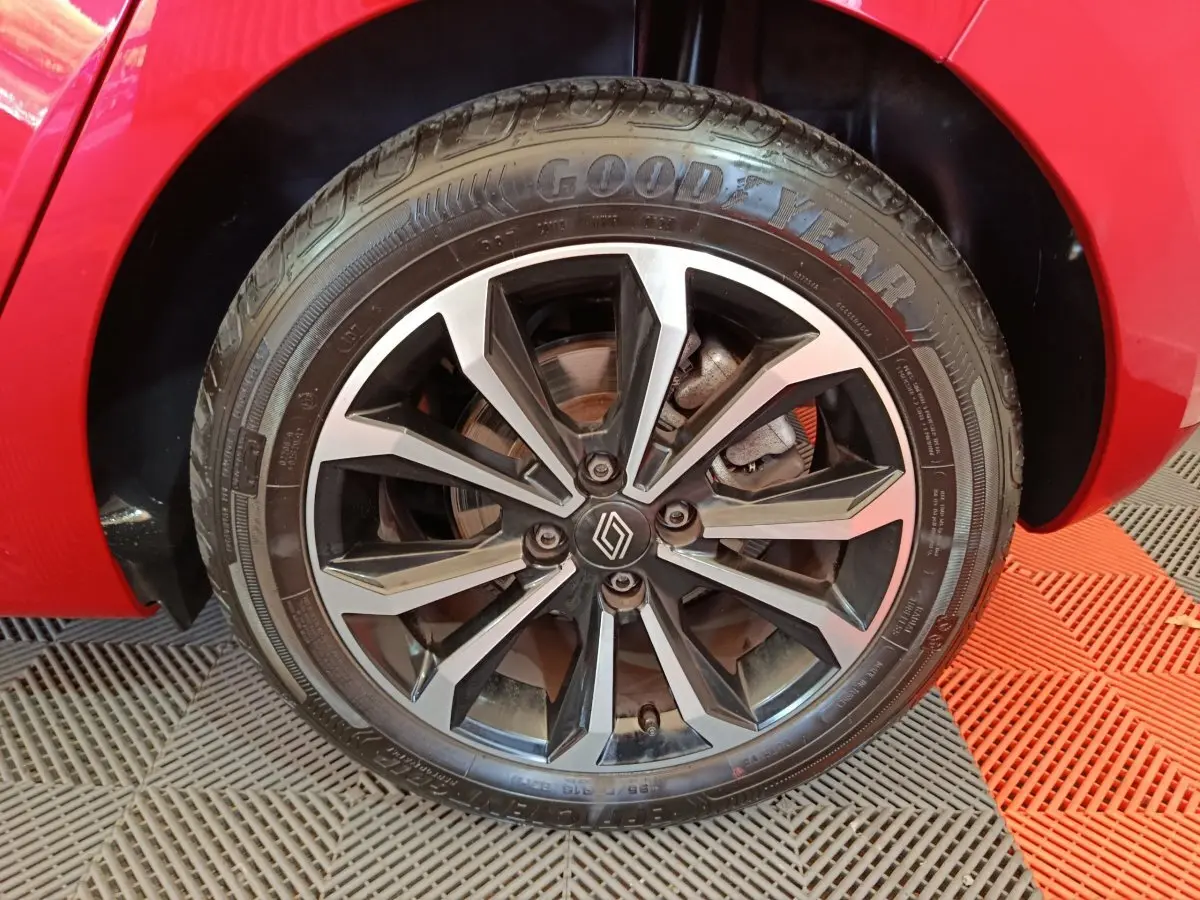 Gros plan sur la roue avant gauche de la Renault Clio Techno TCe 90 rouge avec jante alliage bicolore.