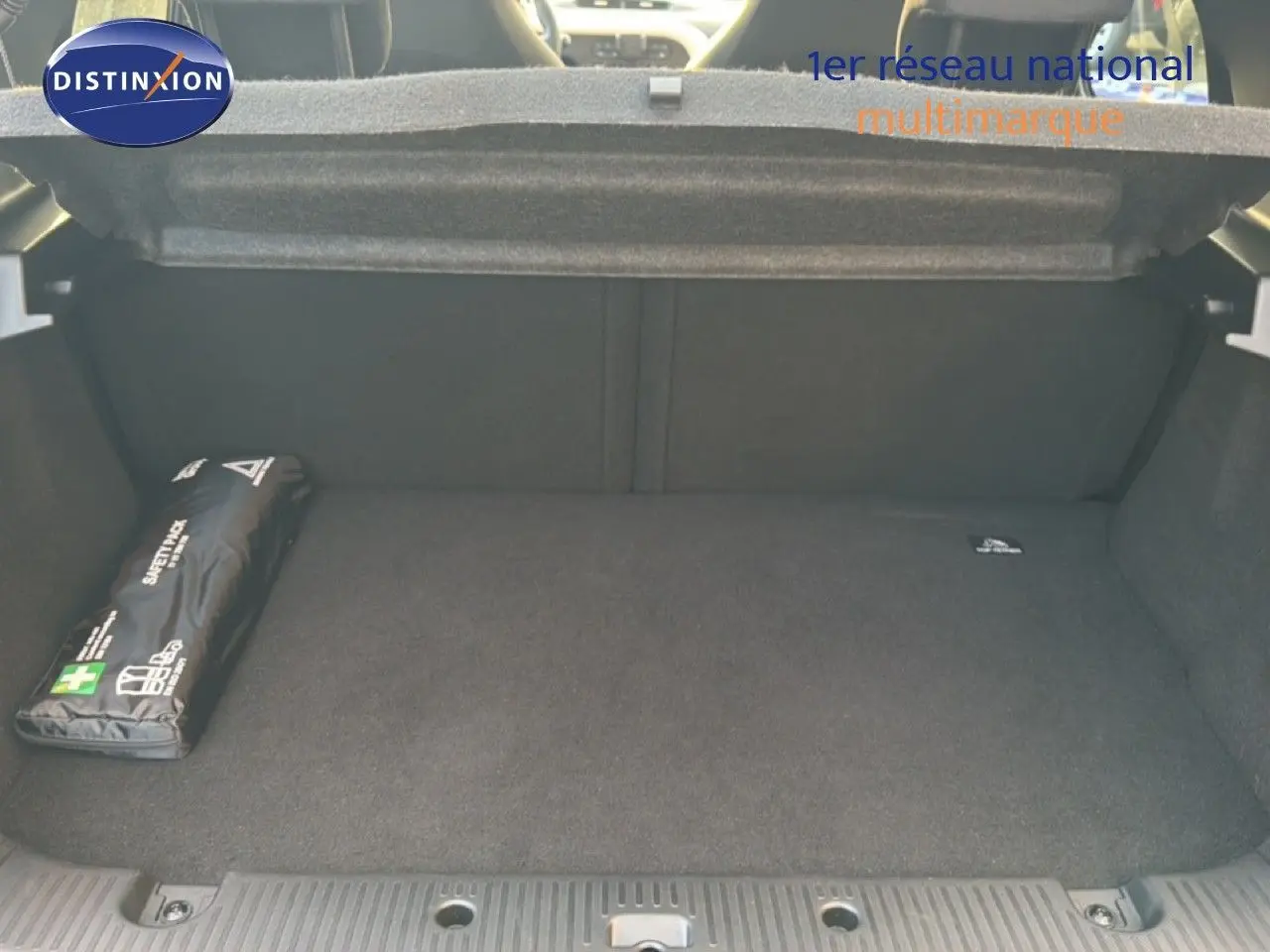 Coffre ouvert vu de l'arrière d'une Renault Twingo gris acier 2021, avec trousse de secours noire à gauche.