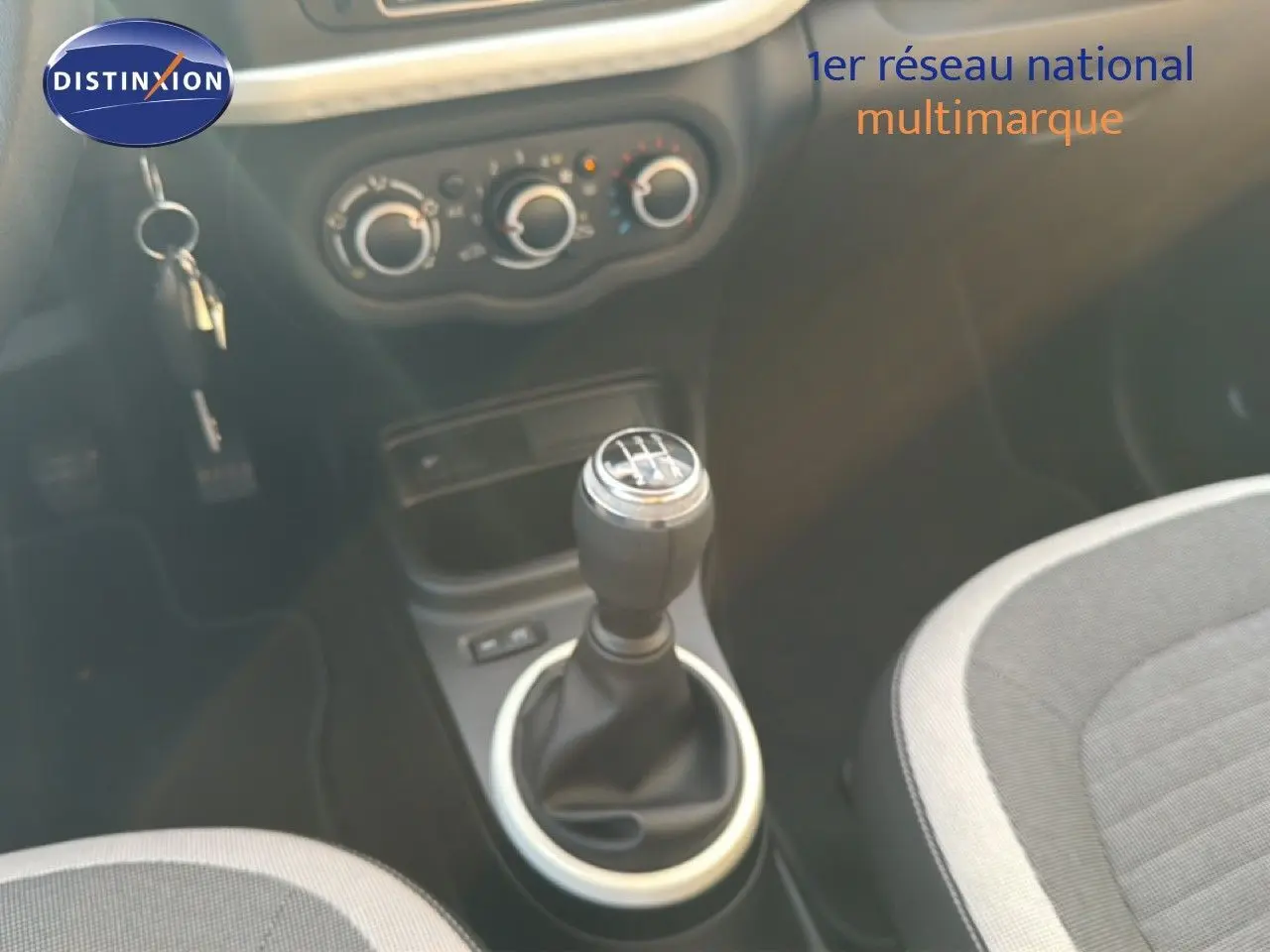 Gros plan sur le levier de vitesses manuel et la console centrale d’une Renault Twingo gris acier, intérieur tissu gris.