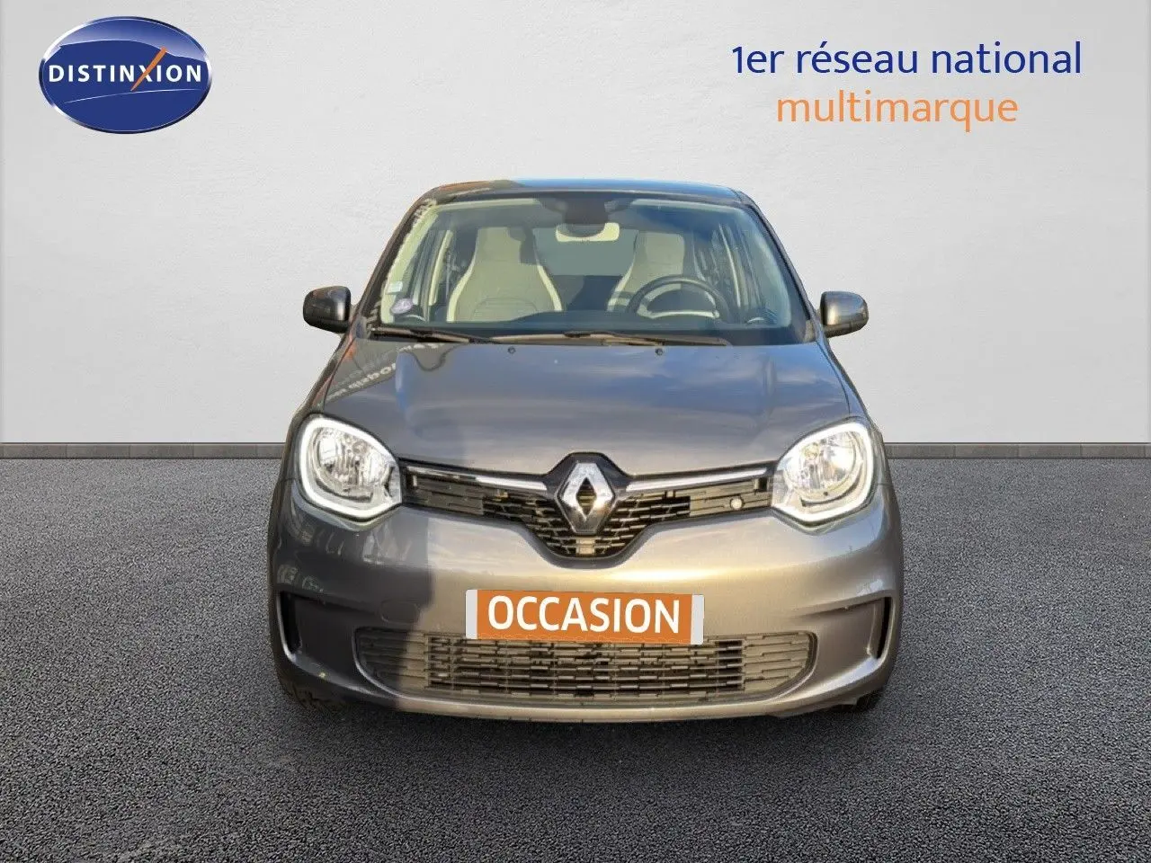 Vue frontale d'une Renault Twingo gris acier 2021 avec calandre noire et phares arrondis, en vente occasion.